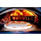 Pizza cooking inside a WPPO Karma wood-fired pizza oven with flames visible