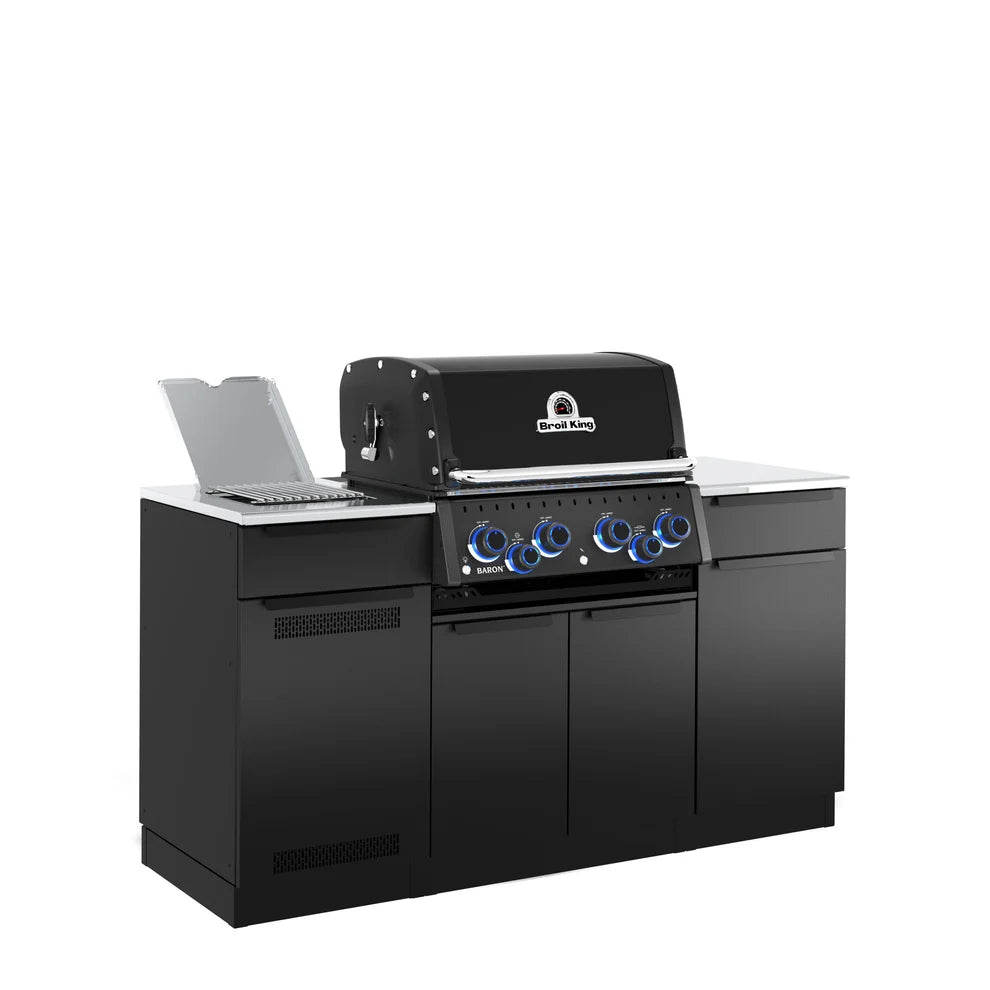 Angled left-side view of the Broil King Baron 490i Pro IR Shadow outdoor kitchen island featuring black cabinetry, stainless steel countertops, an open infrared side burner, and blue illuminated control knobs.