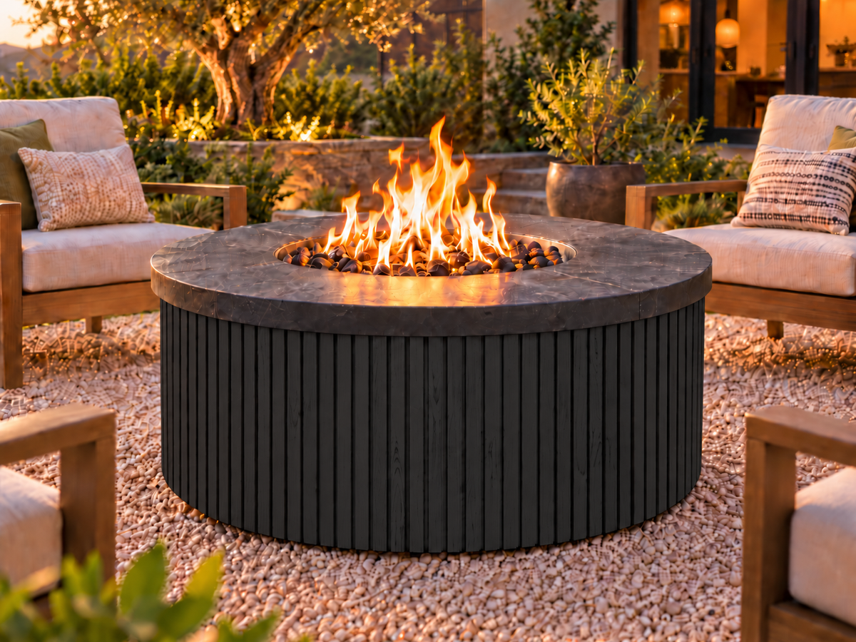 EZ Finish Firefly 48-inch round fire pit with Universal 2+2 aluminum cladding in Black finish, shown lit in an outdoor patio setting.
