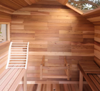Red cedar interior of the ALEKO Bluet 6-person outdoor sauna with bench seating, backrest and skylight.