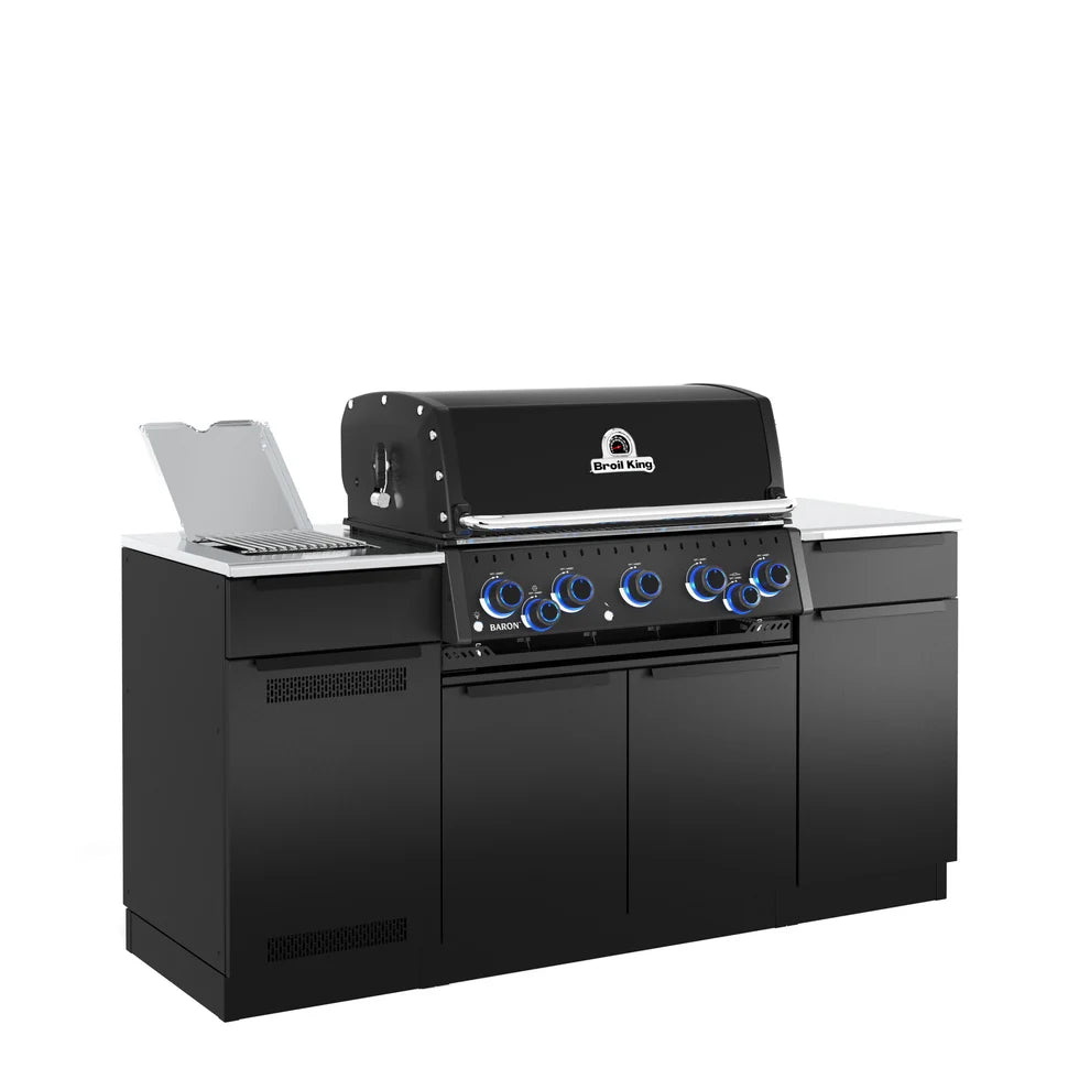 Angled side view of the Broil King Baron 590i Pro IR Shadow outdoor kitchen island featuring black cabinetry, stainless steel countertops, infrared side burner, and illuminated control knobs.