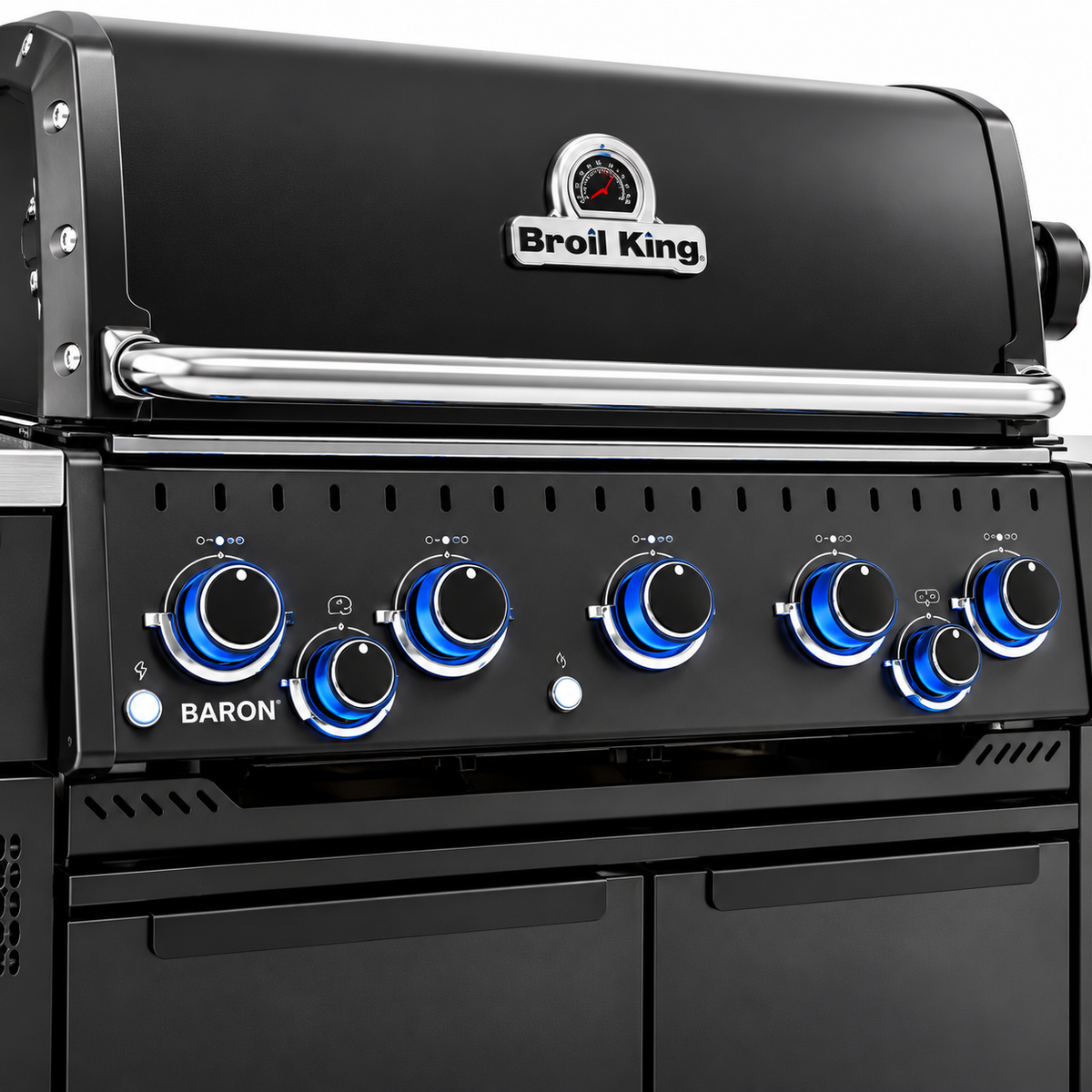 Close-up of the Broil King Baron 590i Pro IR Shadow grill featuring its black hood, built-in thermometer, stainless steel handle, and blue illuminated control knobs.