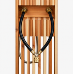 Rear view of cedar outdoor shower showing dual black water supply hoses and brass hose connection fittings.