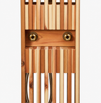 Close-up of cedar slatted outdoor shower panel with brass hot and cold water connection ports.