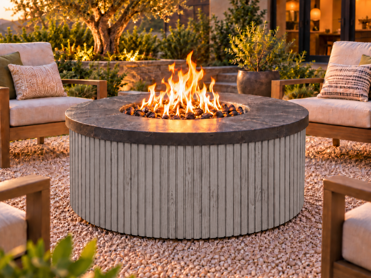 EZ Finish Firefly 48-inch round fire pit with Universal 2+2 aluminum cladding in Grey finish, shown lit in an outdoor patio setting.