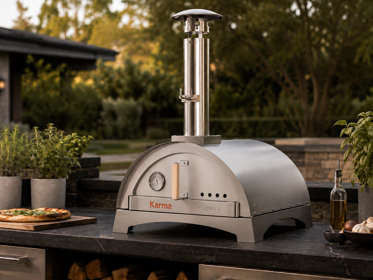 WPPO Karma 25-inch wood-fired pizza oven on an outdoor kitchen countertop with stainless steel chimney
