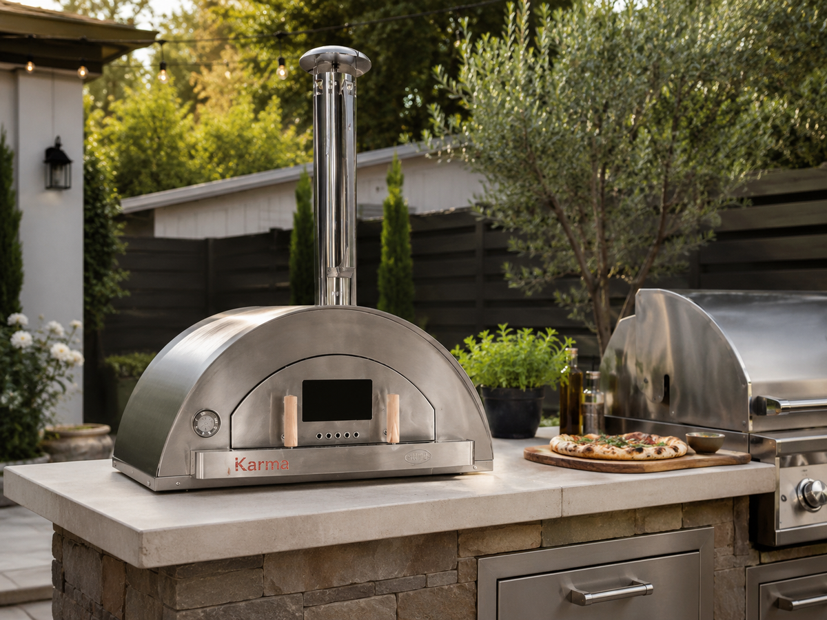 WPPO Karma 42-inch wood-fired pizza oven in a built-in outdoor kitchen with stainless steel grill and countertop