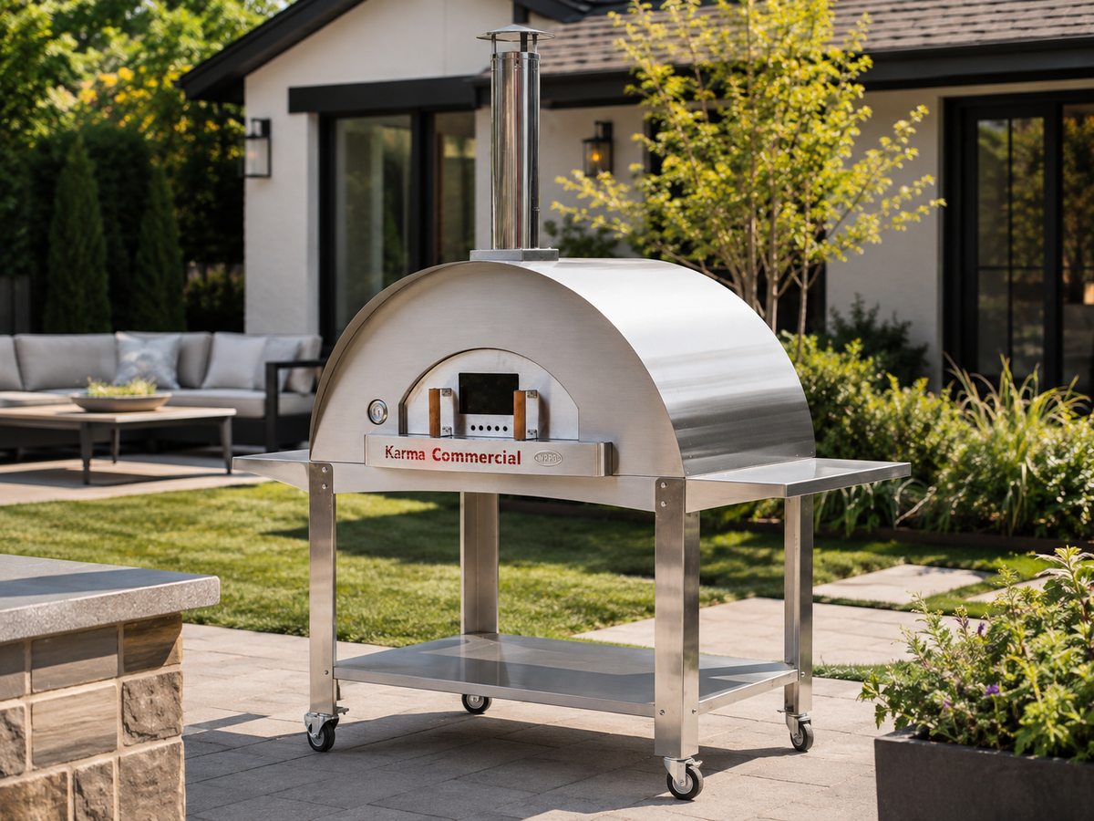 WPPO Karma 55-inch commercial wood-fired pizza oven on a stainless steel mobile cart in a modern backyard patio setting
