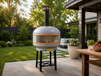 WPPO Lava 40-inch digital wood-fired pizza oven with black stand in a landscaped backyard patio setting