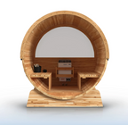 Aleko Liatris barrel sauna interior showing curved cedar walls, facing benches, a central heater, and a panoramic rear window.