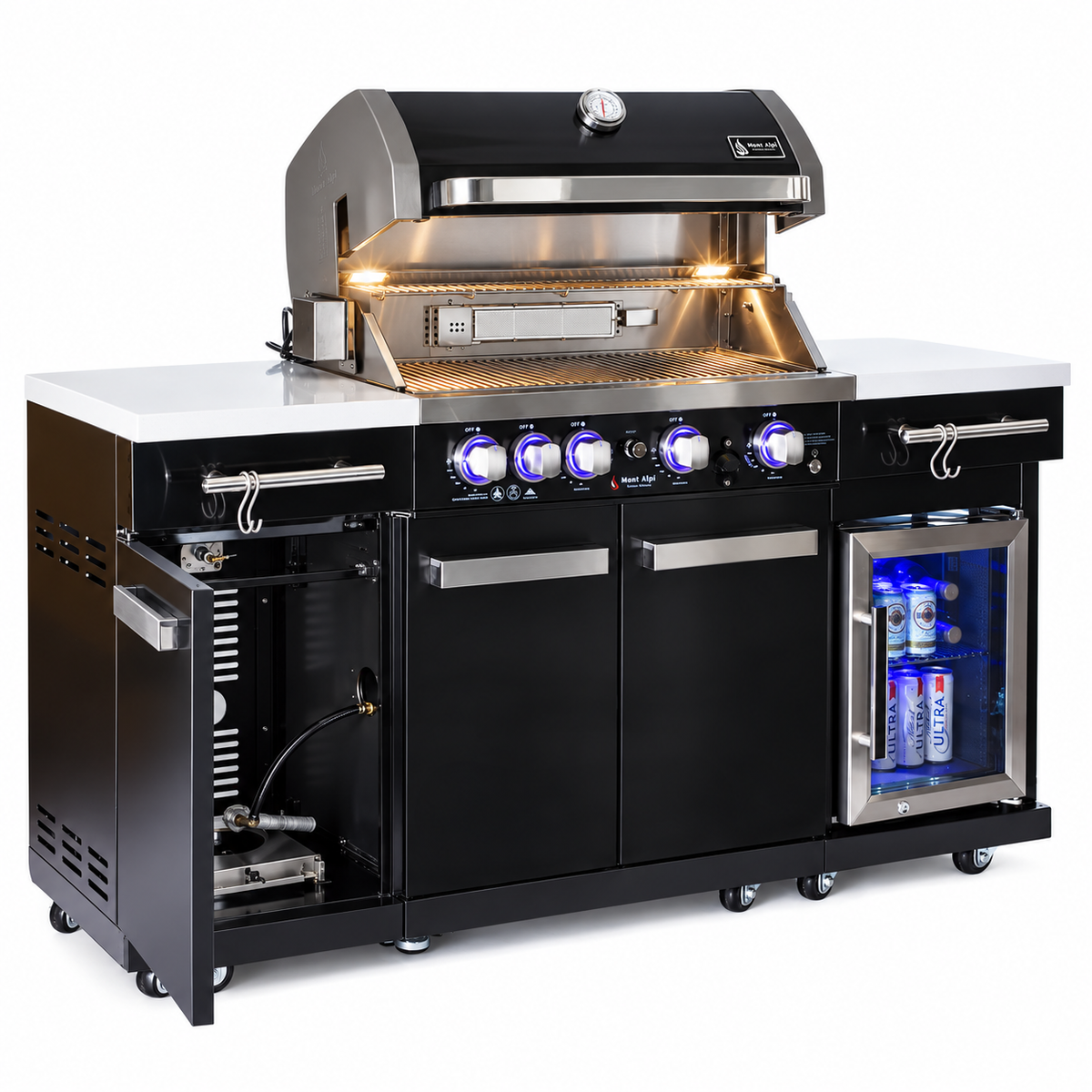 Mont Alpi 957 Compact black stainless steel outdoor kitchen with open grill hood, illuminated cooking interior, open side cabinet showing gas connections, and built-in beverage refrigerator