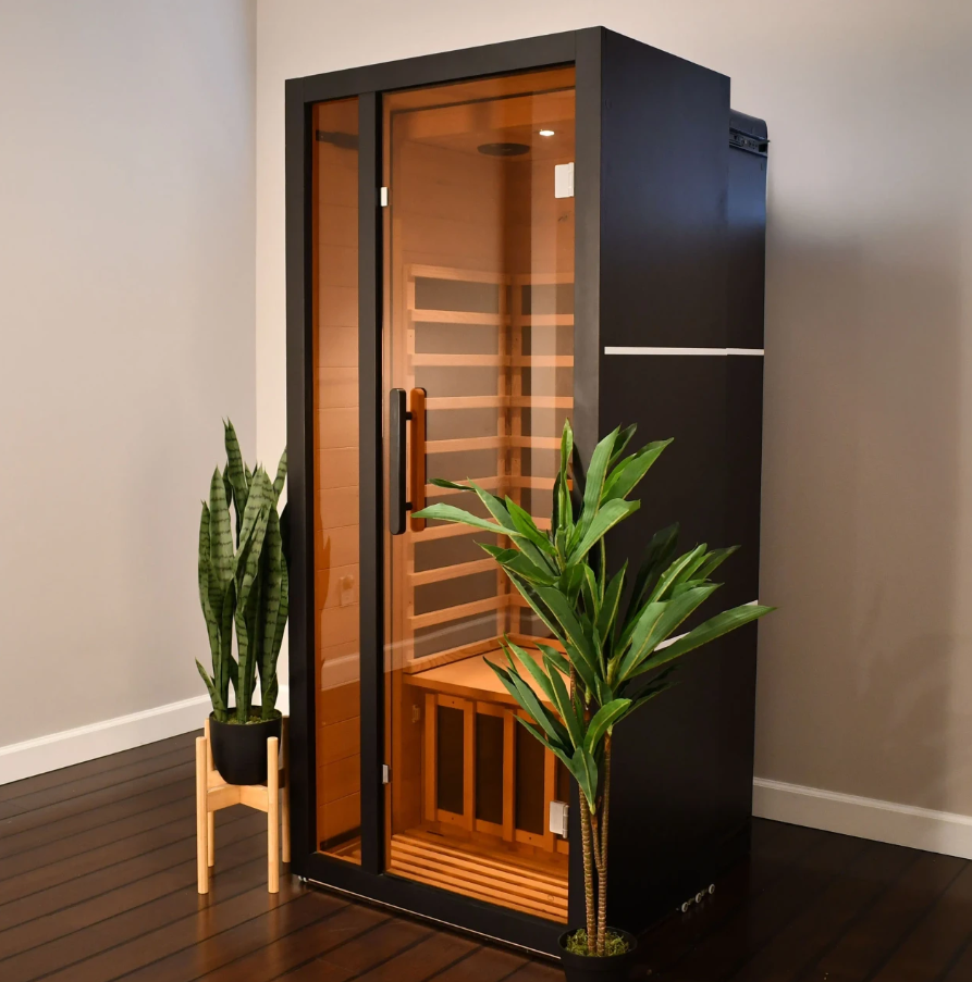 ALEKO Oasis 1-Person Infrared Sauna with black exterior and illuminated hemlock interior in a modern home setting