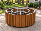 EZ Finish Firefly 48-inch round aluminum-clad fire pit enclosure shown without countertop or burner components on a wooded suburban backyard patio.