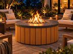 EZ Finish Firefly 48-inch round aluminum-clad fire pit shown lit at night in a landscaped backyard patio seating area.