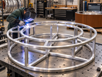 EZ Finish Firefly 48-inch round fire pit aluminum frame being welded during fabrication in a workshop.